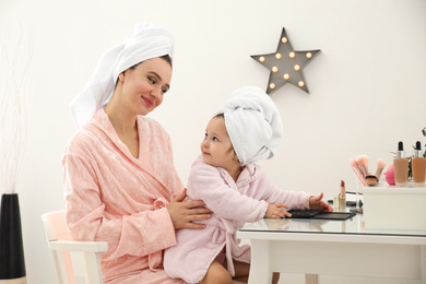 Young mother and little daughter at dressing table