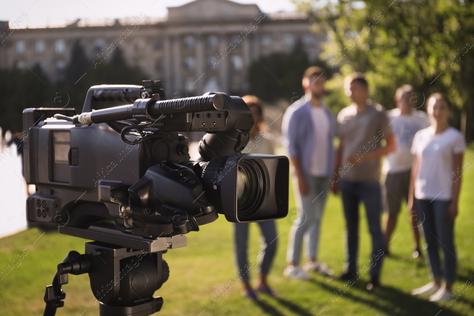 Photo of Professional video camera outdoors and group of people on background