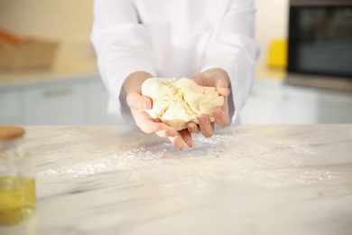 Chef cooking dough at table in kitchen, closeup