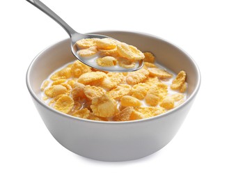 Photo of Spoon of delicious crispy corn flakes with milk above bowl on white background