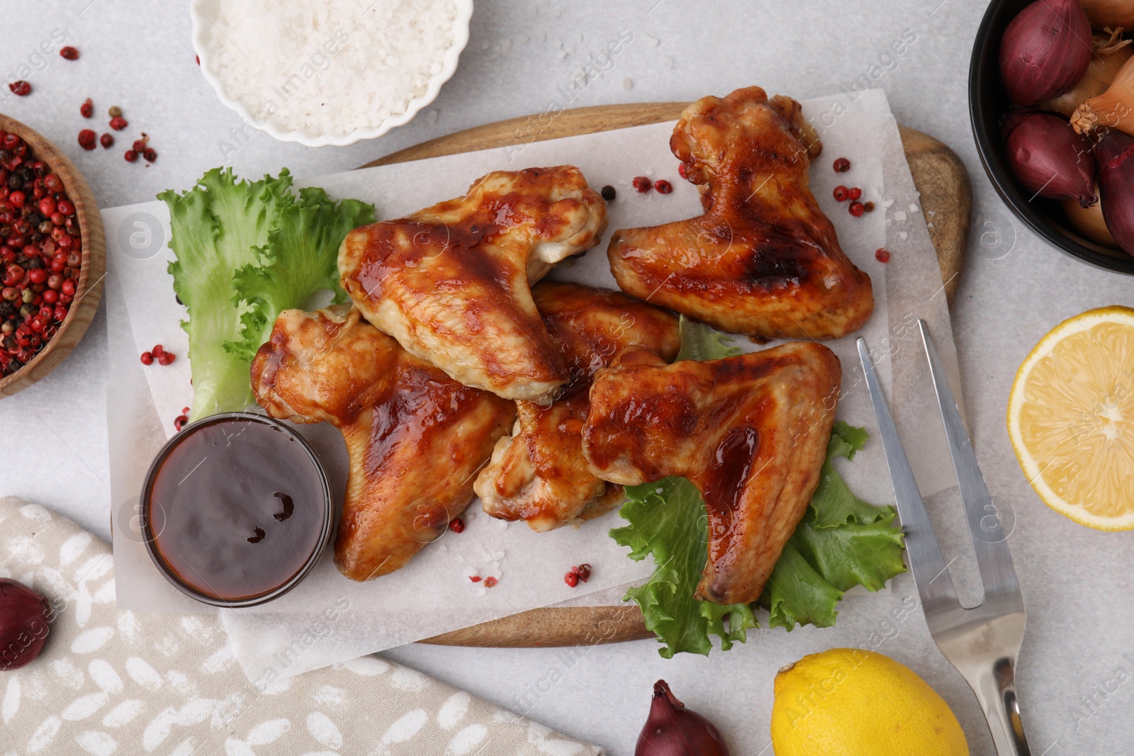 Photo of Flat lay composition with marinade, chicken wings and other products on light table