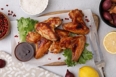 Photo of Flat lay composition with marinade, chicken wings and other products on light table