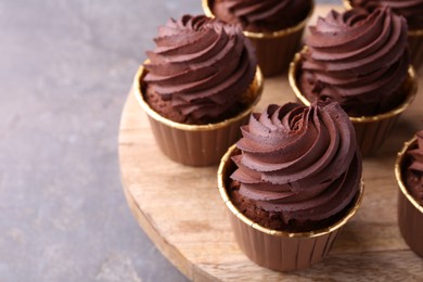 Photo of Delicious chocolate cupcakes on grey table, closeup