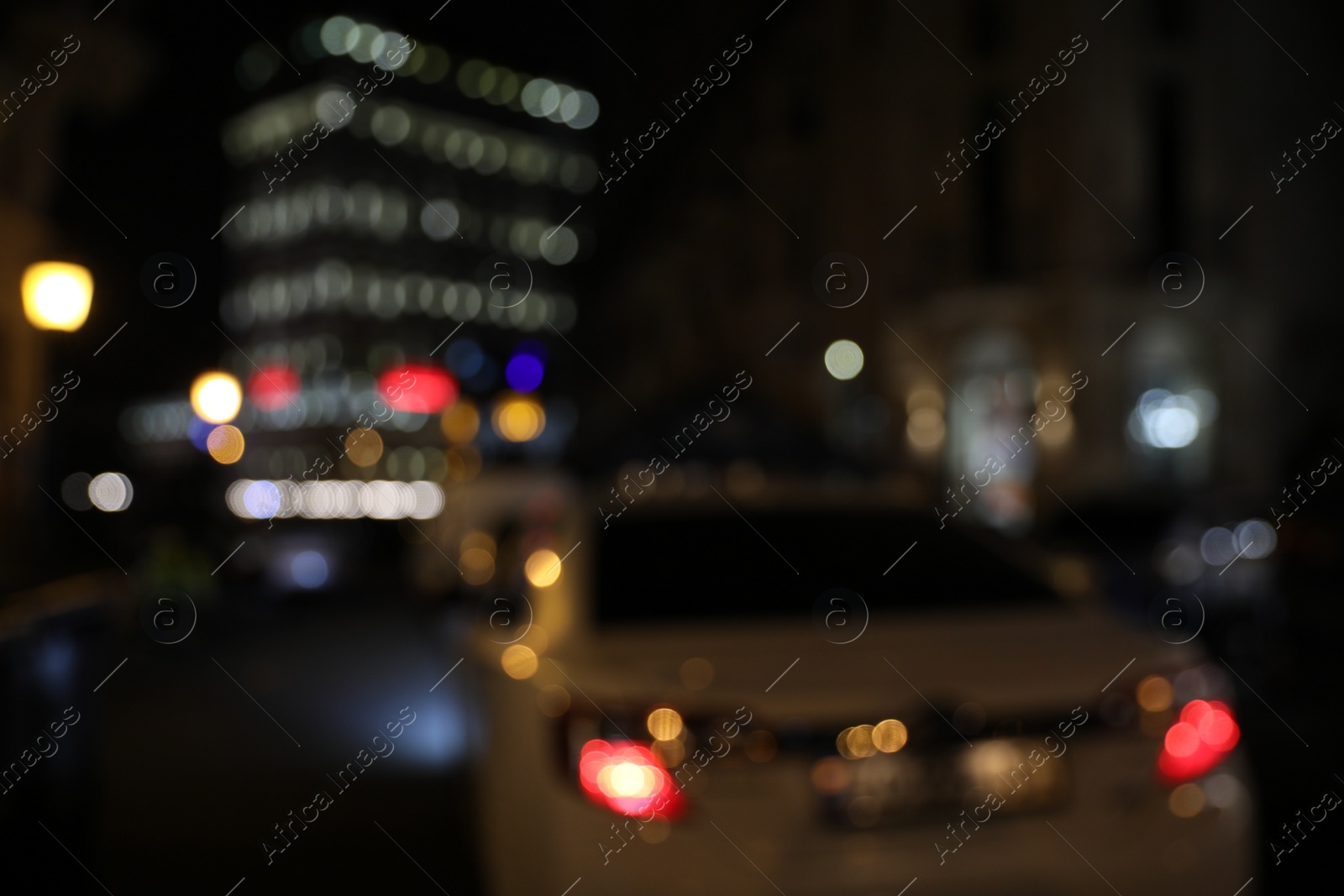 Photo of Blurred view of beautiful cityscape with glowing streetlights and cars at night