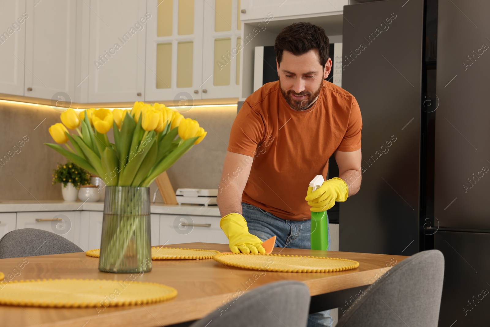 Photo of Spring cleaning. Man tidying up kitchen at home