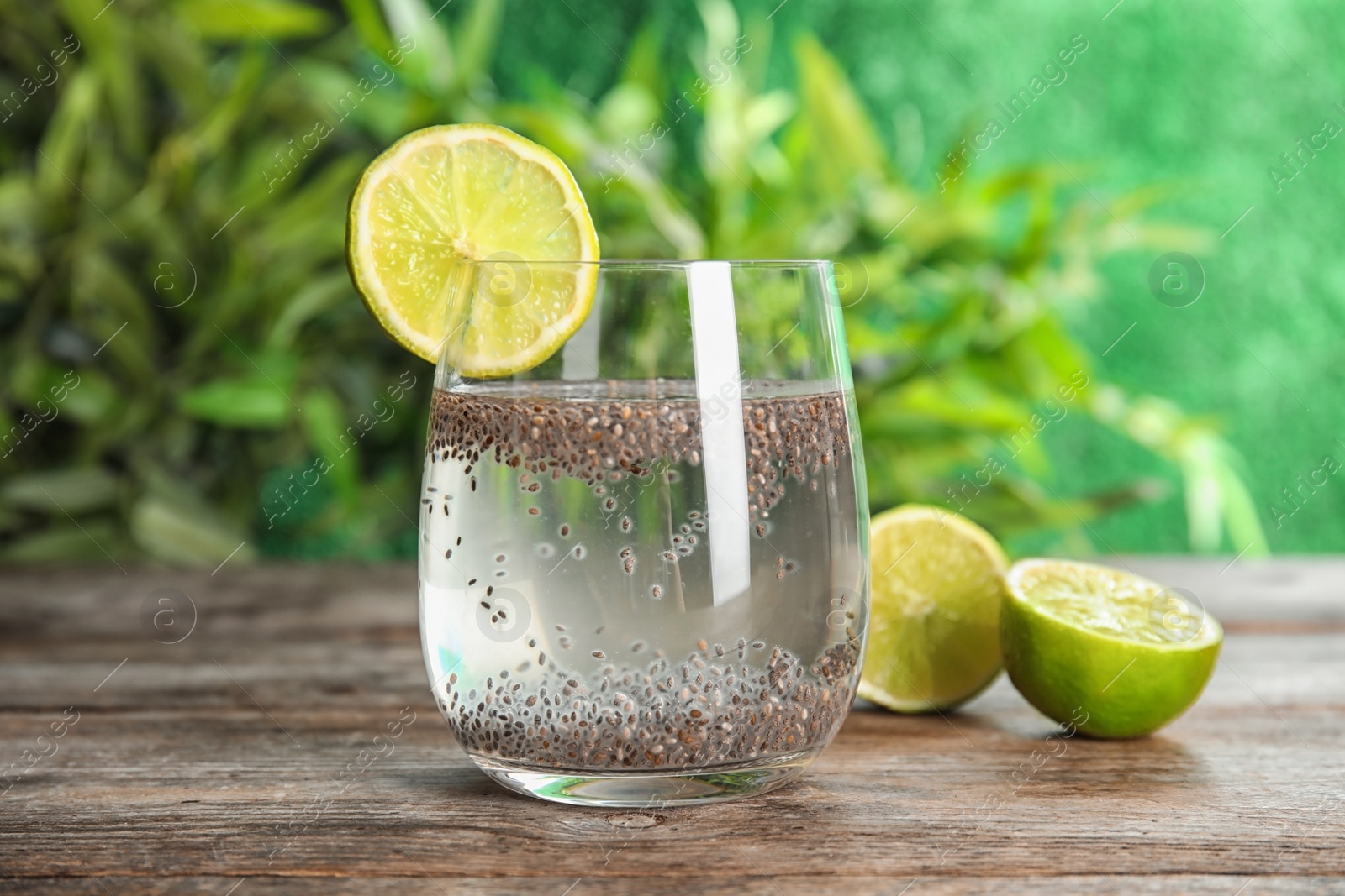 Photo of Glass of water with chia seeds and lime on table