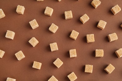 Photo of Brown sugar cubes on color background, top view