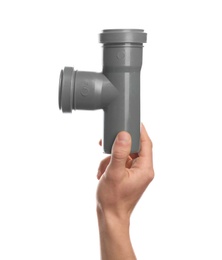 Male plumber holding pipe fitting on white background, closeup