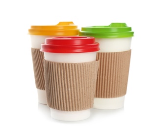 Takeaway paper coffee cups with lids and cardboard sleeves on white background