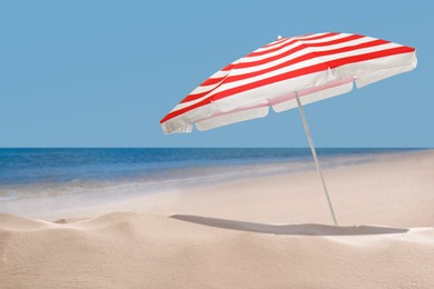 Open big beach umbrella on sandy coast 