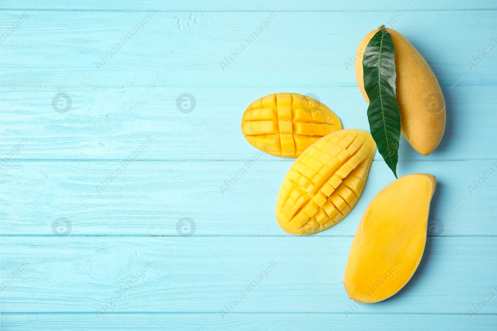 Photo of Flat lay composition with mango on wooden background. Space for text