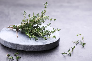 Photo of Bunch of fresh thyme on grey table