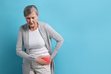 Image of Senior woman suffering from pain in hip on light blue background. Space for text