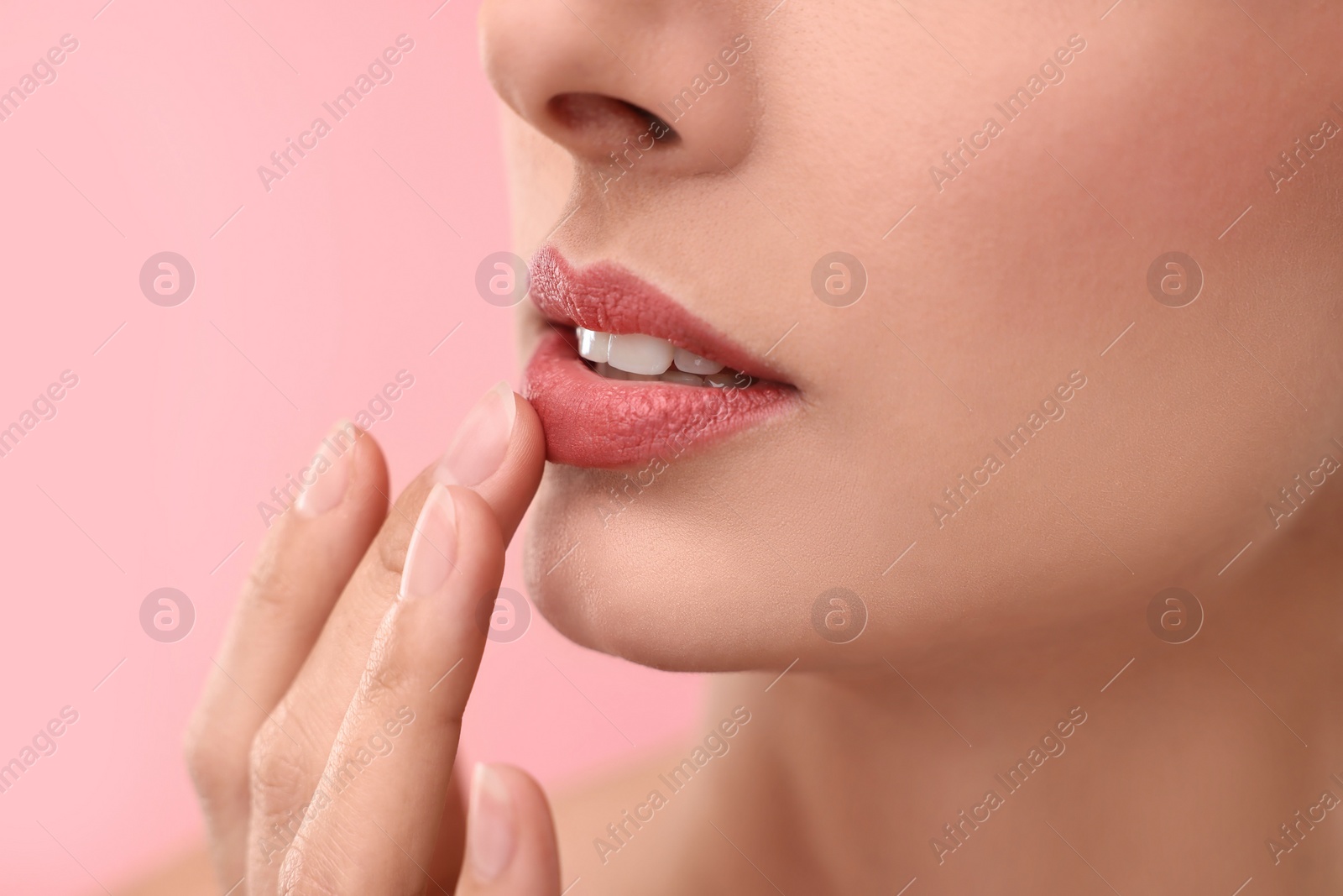 Photo of Woman with beautiful lips on pink background, closeup