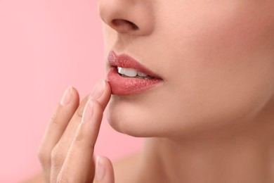 Woman with beautiful lips on pink background, closeup