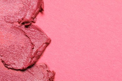 Photo of Smears of bright lipstick on pink background, top view. Space for text