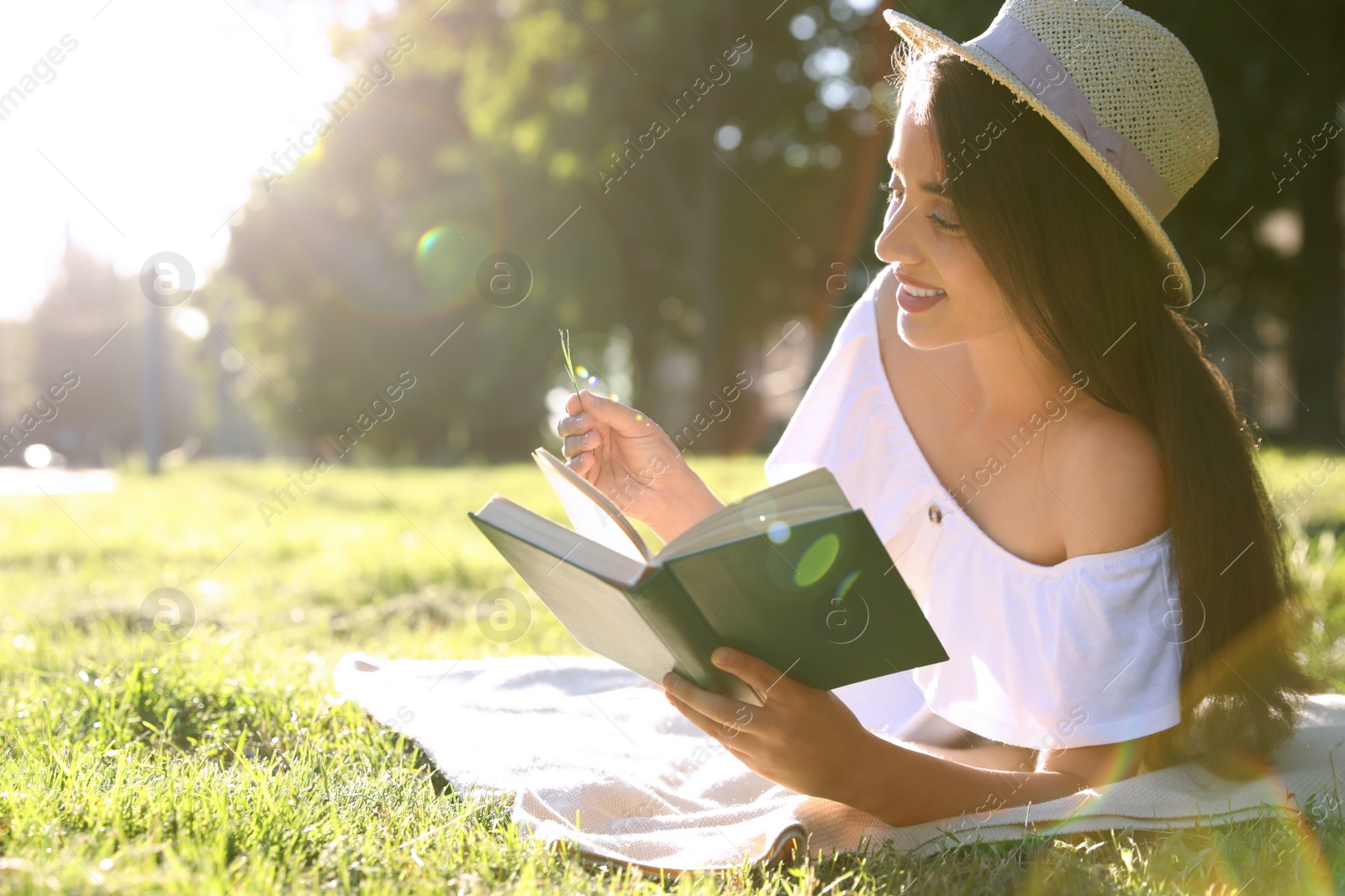 Photo of Beautiful young woman reading book in park