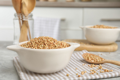 Photo of Bowl with green buckwheat on marble table