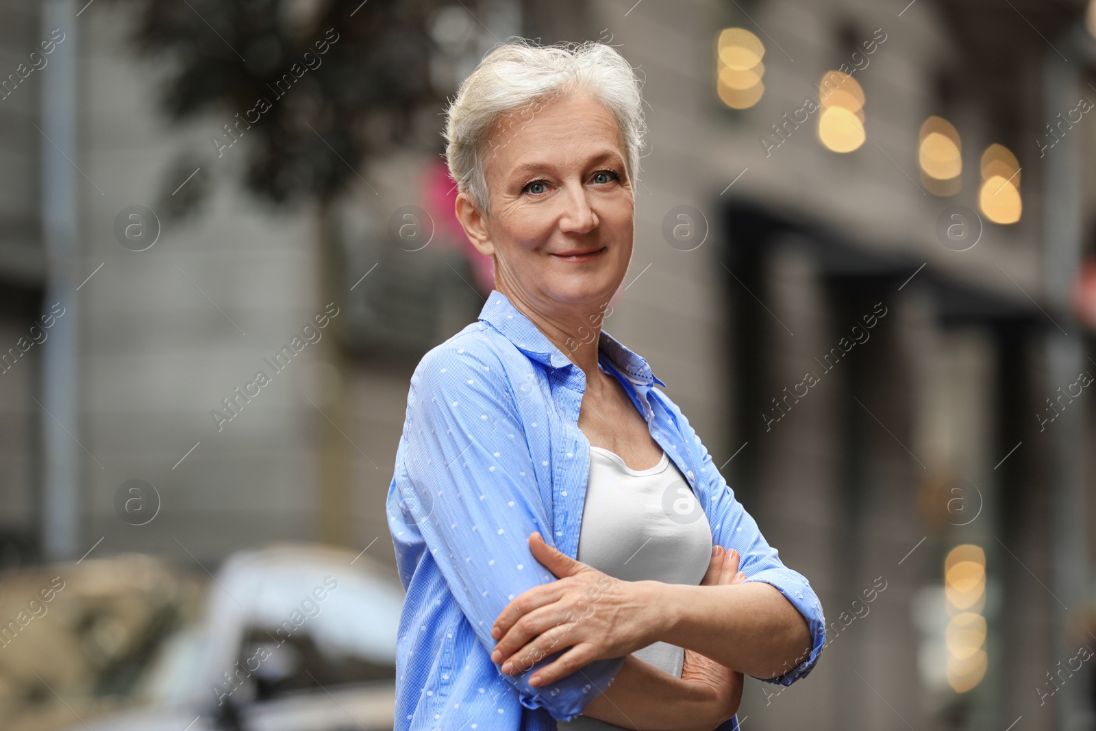 Photo of Happy mature woman on city street. Smart aging