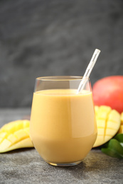 Photo of Fresh delicious mango drink on grey table