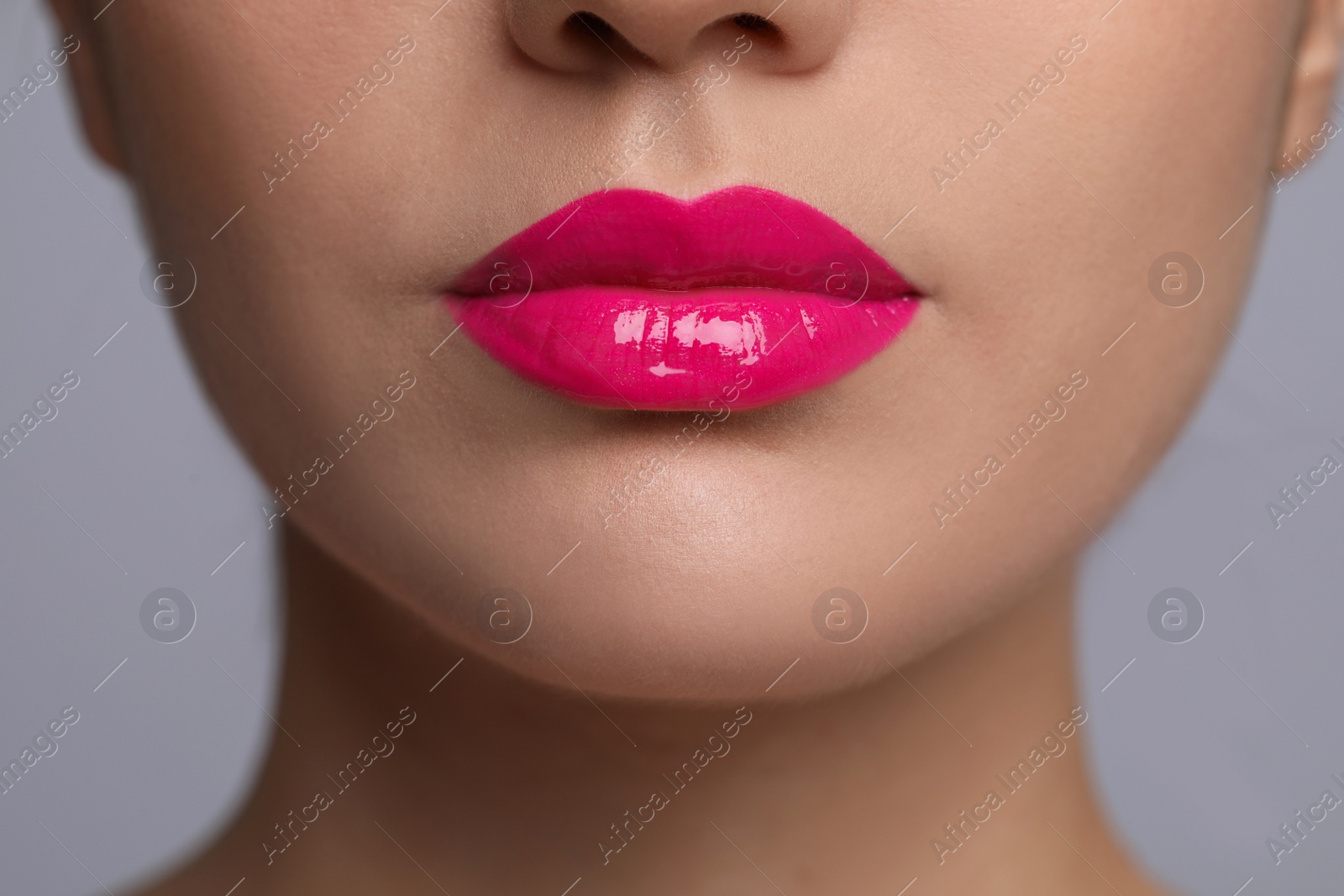 Photo of Closeup view of woman with beautiful full lips on grey background