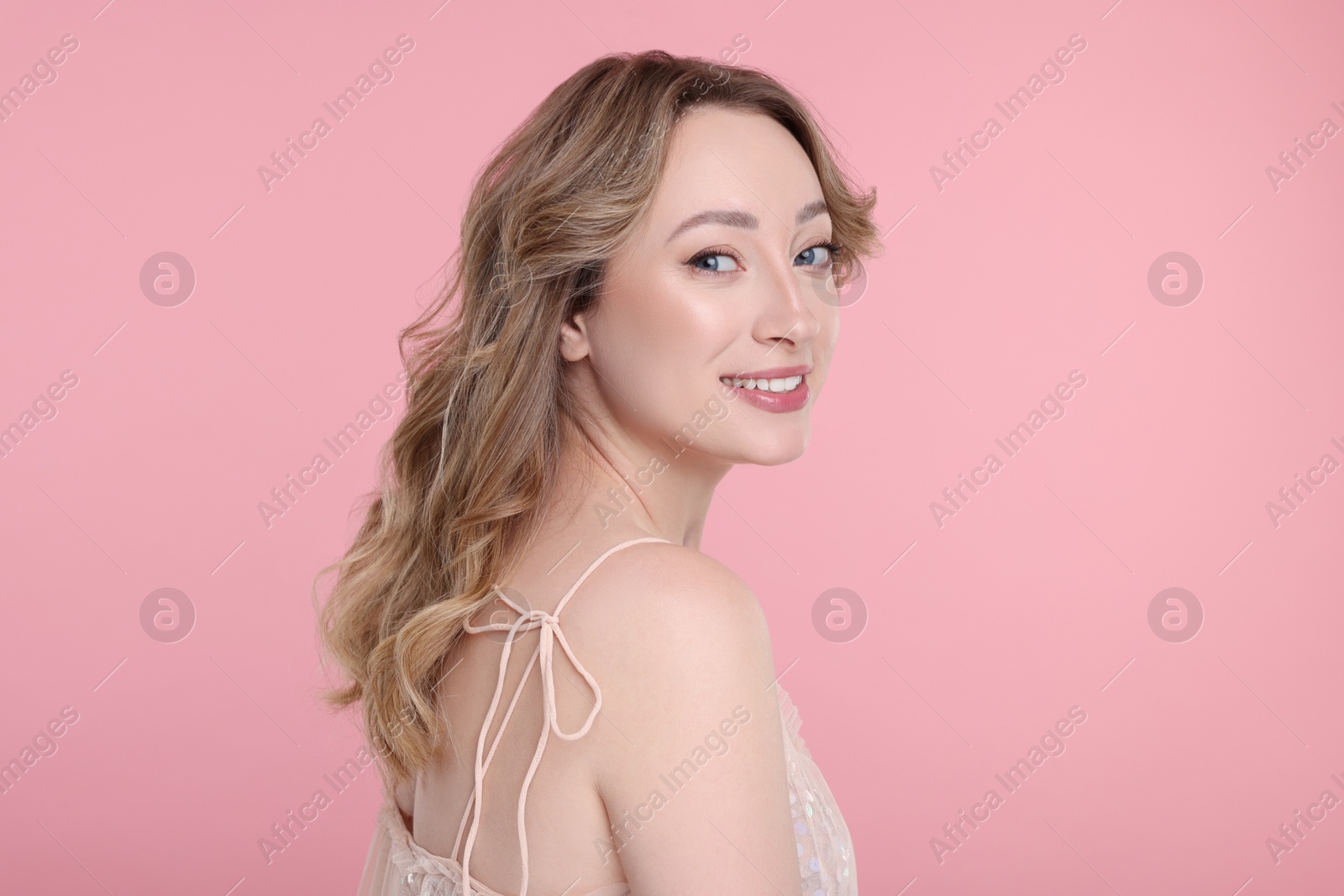 Photo of Portrait of smiling woman on pink background