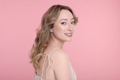 Portrait of smiling woman on pink background