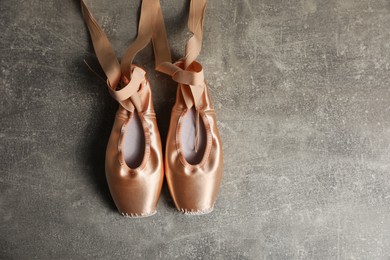 Photo of Ballet shoes. Elegant pointes on grey textured background, flat lay