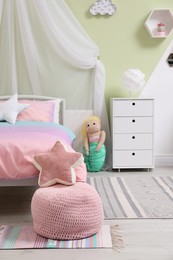 Photo of Cute child's room interior with comfortable bed and cushions