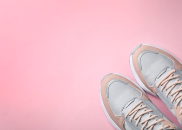 Photo of Pair of stylish sneakers on color background, top view. Space for text