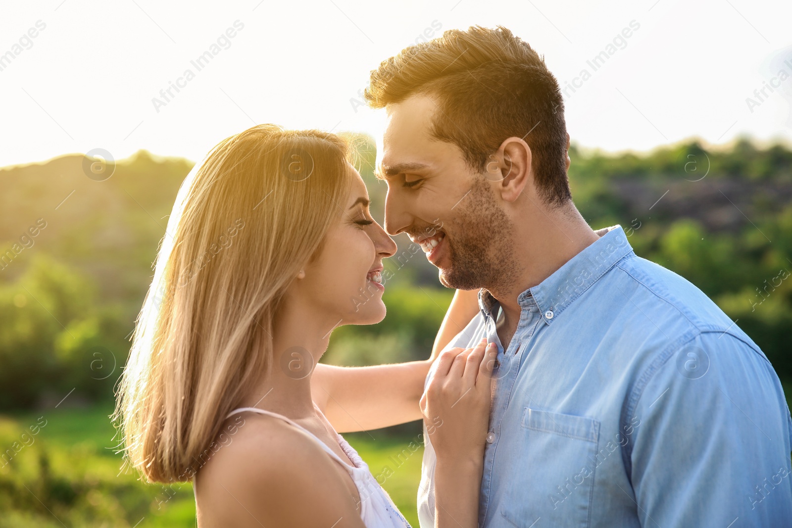 Photo of Cute young couple in love posing outdoors on sunny day