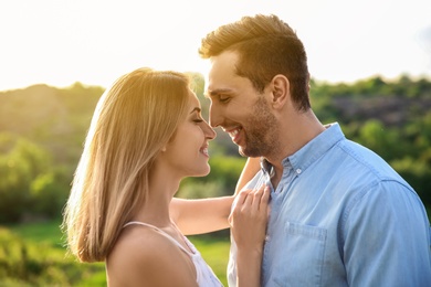 Photo of Cute young couple in love posing outdoors on sunny day