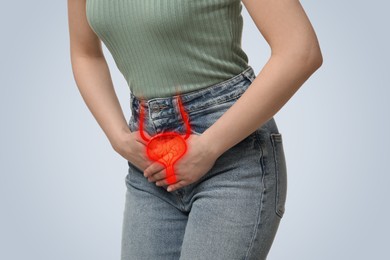 Woman suffering from cystitis on light background, closeup. Illustration of urinary system