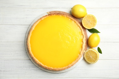 Photo of Delicious homemade lemon pie and fruits on white wooden table, flat lay