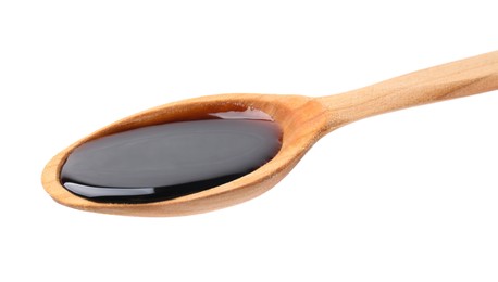 Wooden spoon with delicious caramel syrup isolated on white