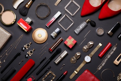 Photo of Flat lay composition with different makeup products and women's accessories on black background