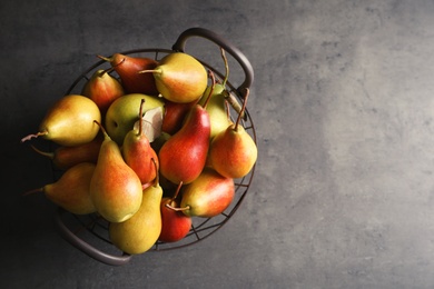 Photo of Basket with ripe pears on grey background, top view. Space for text