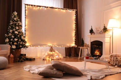 Blank video projector screen in room decorated for Christmas. Cozy atmosphere