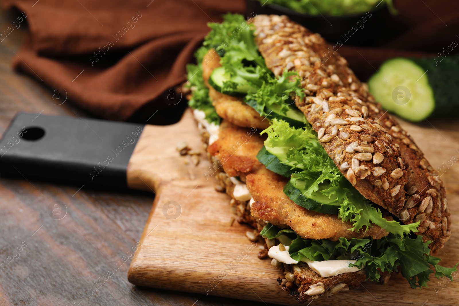 Photo of Delicious sandwich with schnitzel on wooden table, closeup. Space for text