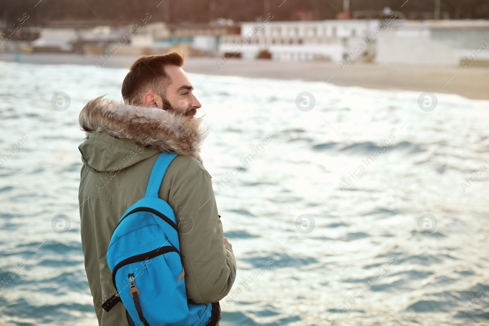 Photo of Stylish young man with backpack near sea