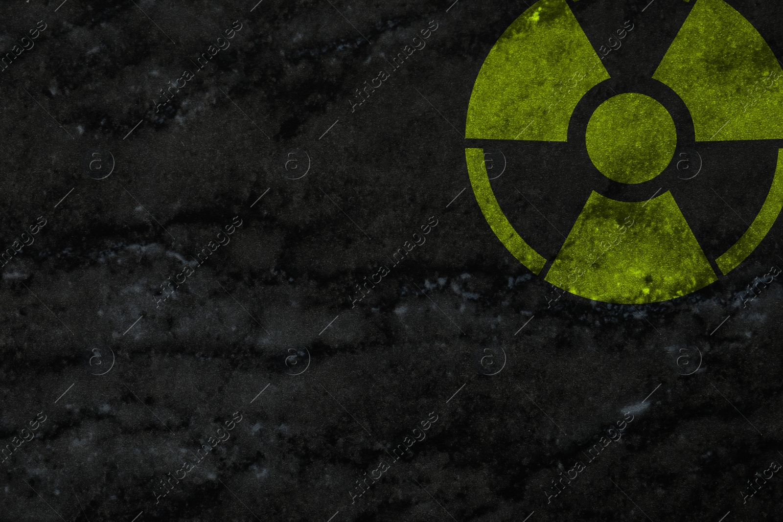 Image of Radioactive sign on dark marble wall, space for text. Hazard symbol