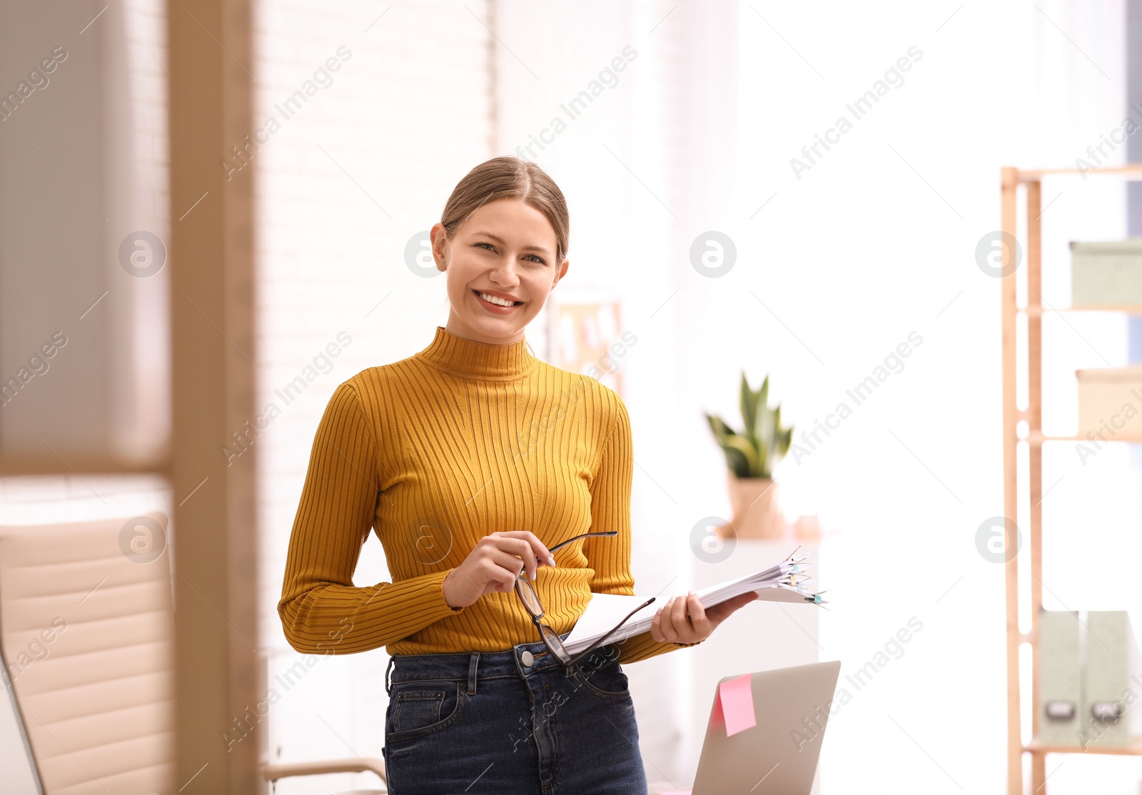 Photo of Young journalist at workplace in light office