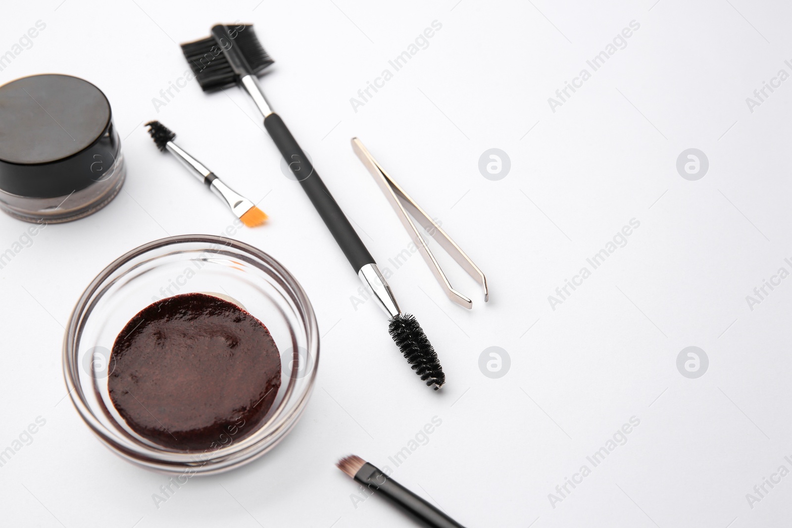 Photo of Eyebrow henna and professional tools on white background, space for text
