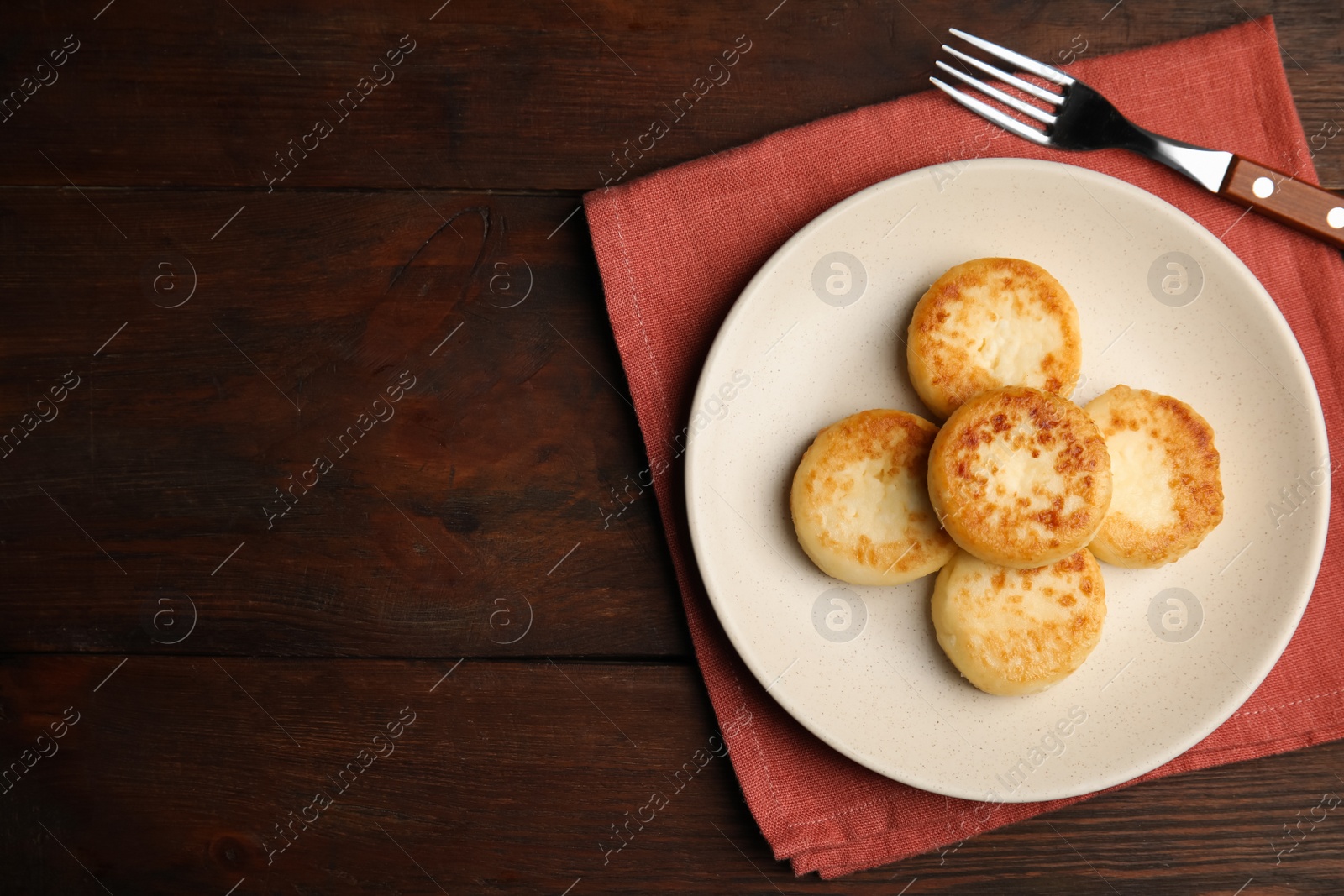 Photo of Delicious cottage cheese pancakes on wooden table, flat lay. Space for text