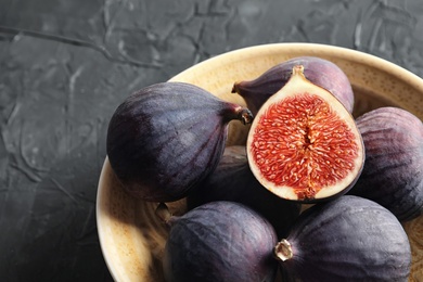 Bowl with fresh ripe figs on dark background. Tropical fruit