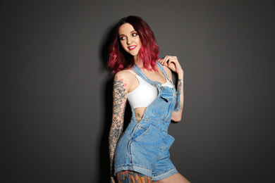 Beautiful woman with tattoos on body against black background