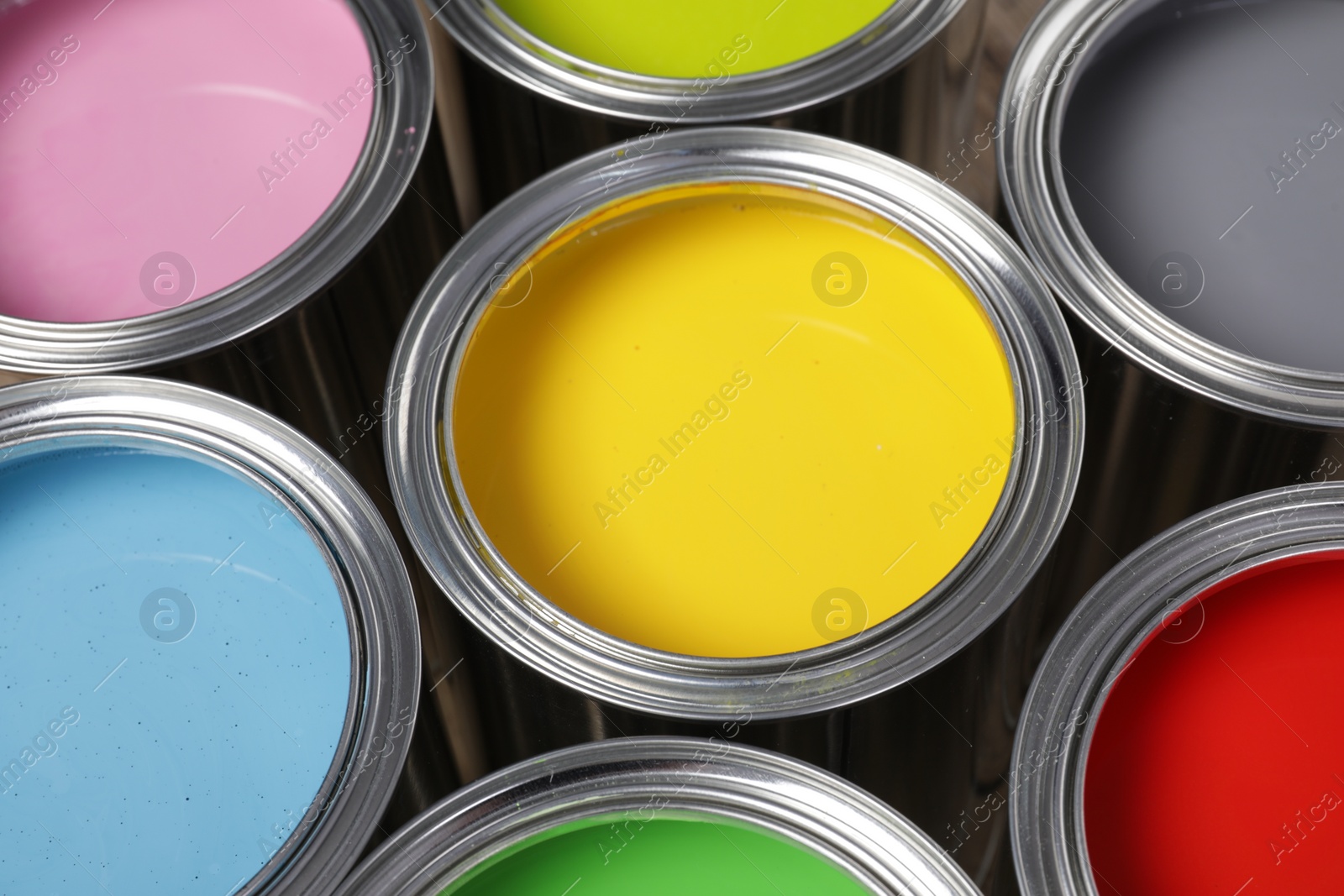 Photo of Open cans of different paints as background, closeup