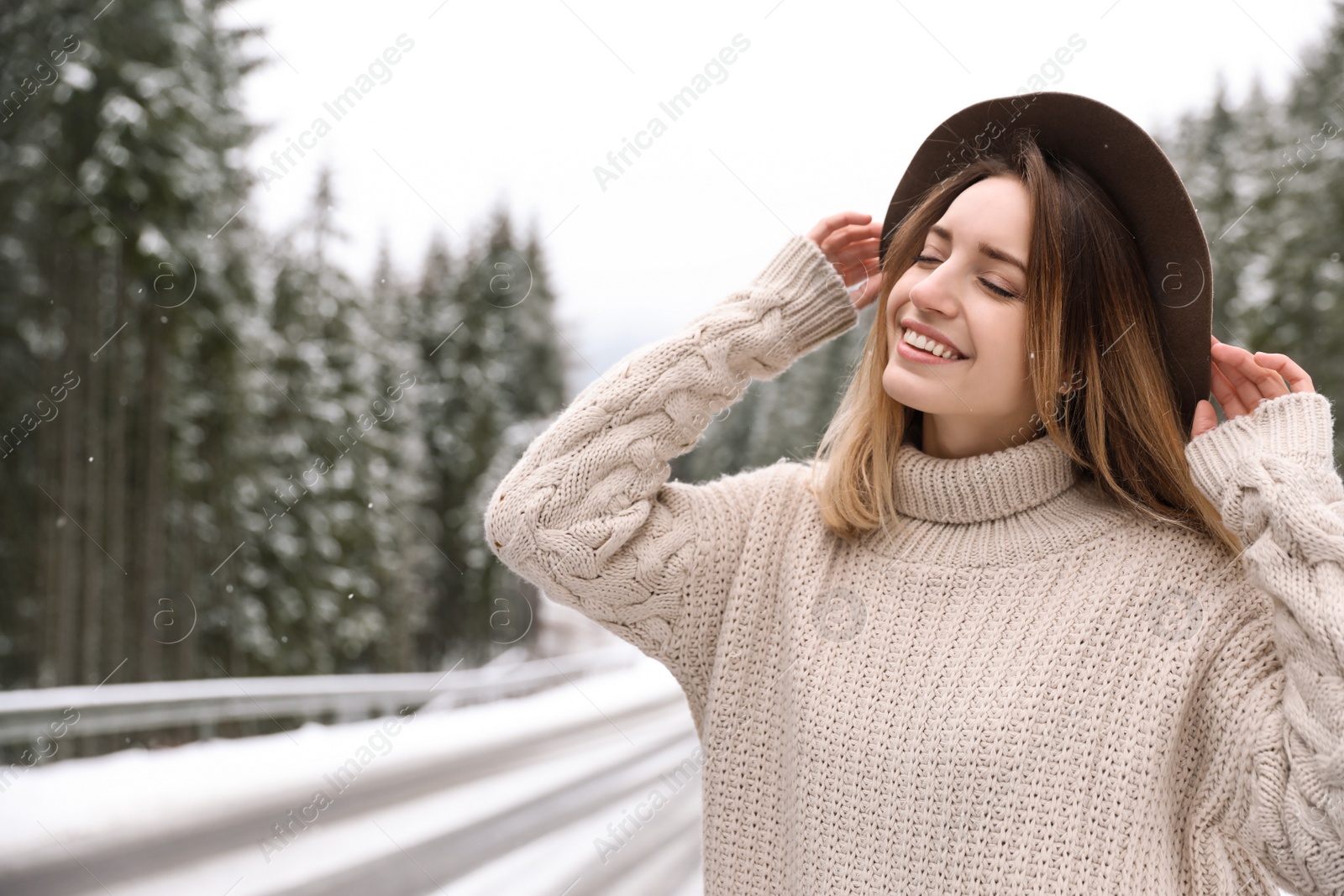 Photo of Young woman in warm sweater outdoors. Winter vacation