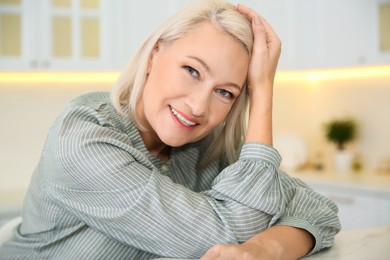 Photo of Portrait of beautiful mature woman in kitchen