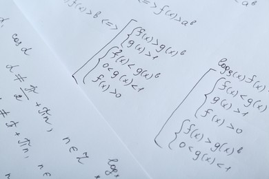 Sheets of paper with different mathematical formulas, closeup